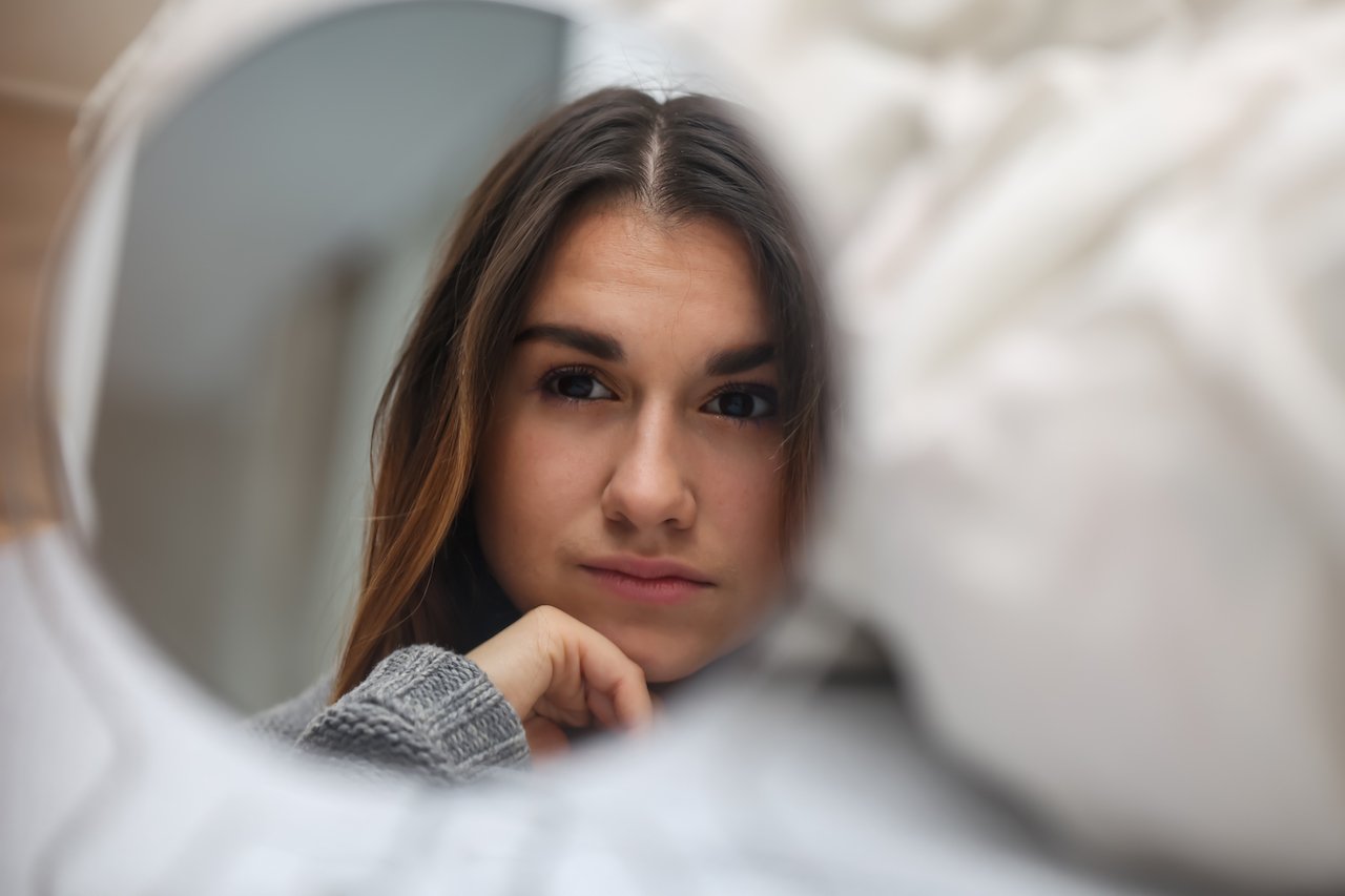 Woman examining impact of daily skincare routine on skin
