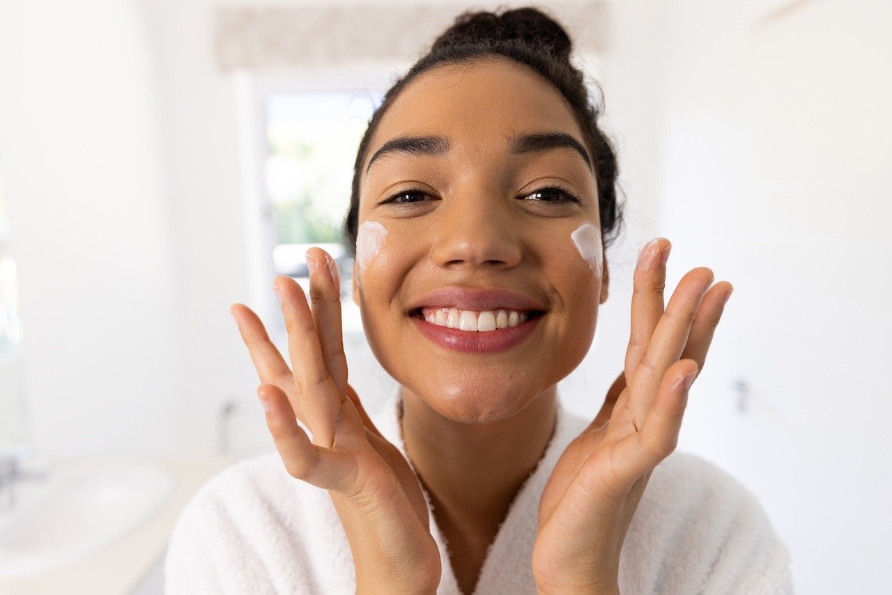 woman hydrating skin with quality moisturizer