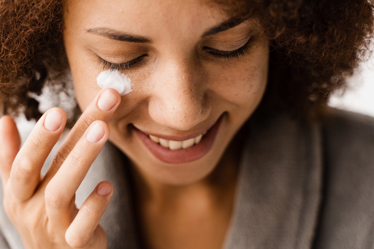 woman applying moisturizer during a skin cycling routine