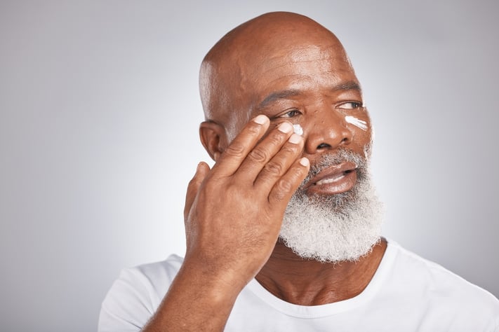 aged man putting eye cream on to nourish eye area