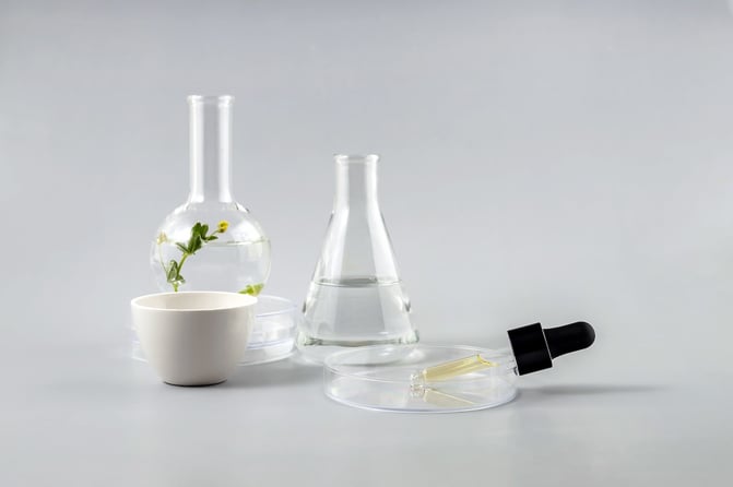 laboratory glassware and skincare dropper used to represent cosmetic formulation and ingredient testing
