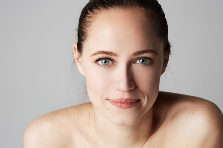 close up of woman with healthy, radiant skin supported by skin cycling