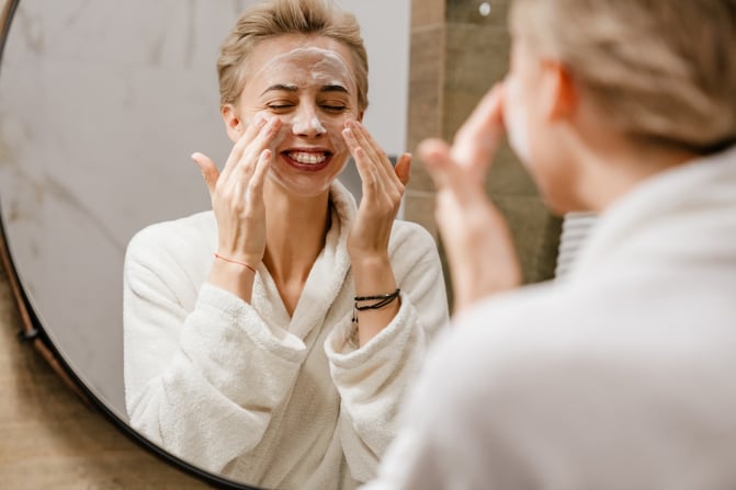 woman cleansing her face as part of a night skincare routine