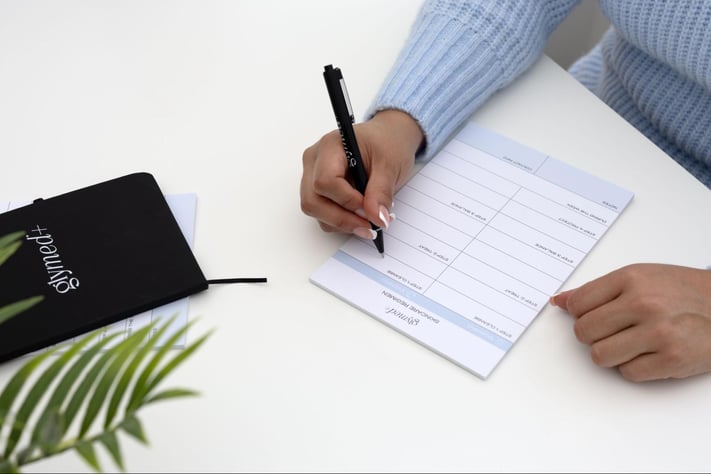 person filling out skincare regimen planner