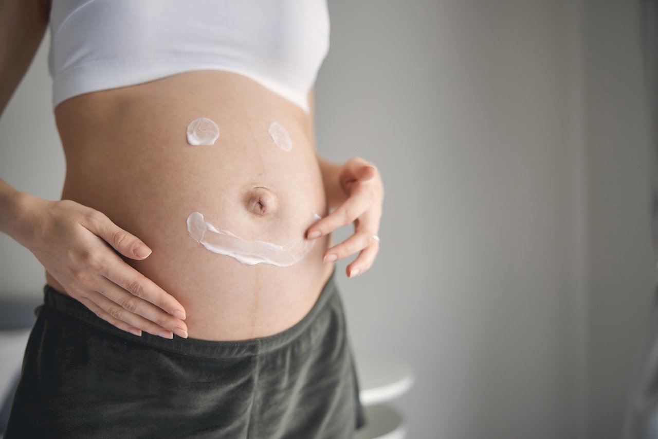 pregnant woman applying cream to prevent stretch marks