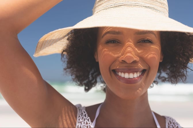 smiling woman protecting her face from the sun