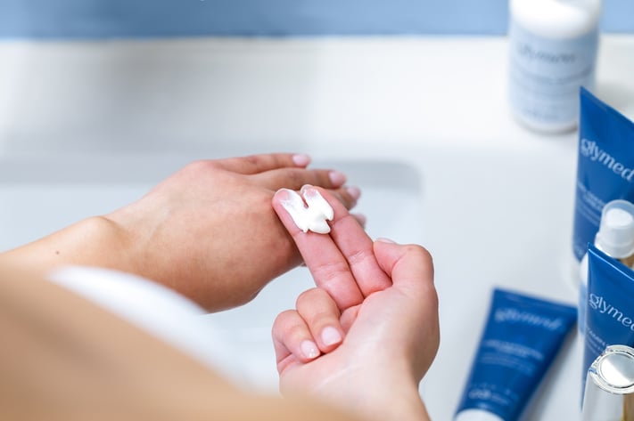 woman applying moisturizer to manage retinol peeling